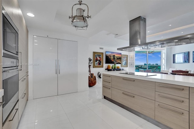 kitchen featuring light tile patterned flooring, light brown cabinets, island exhaust hood, oven, and black electric stovetop