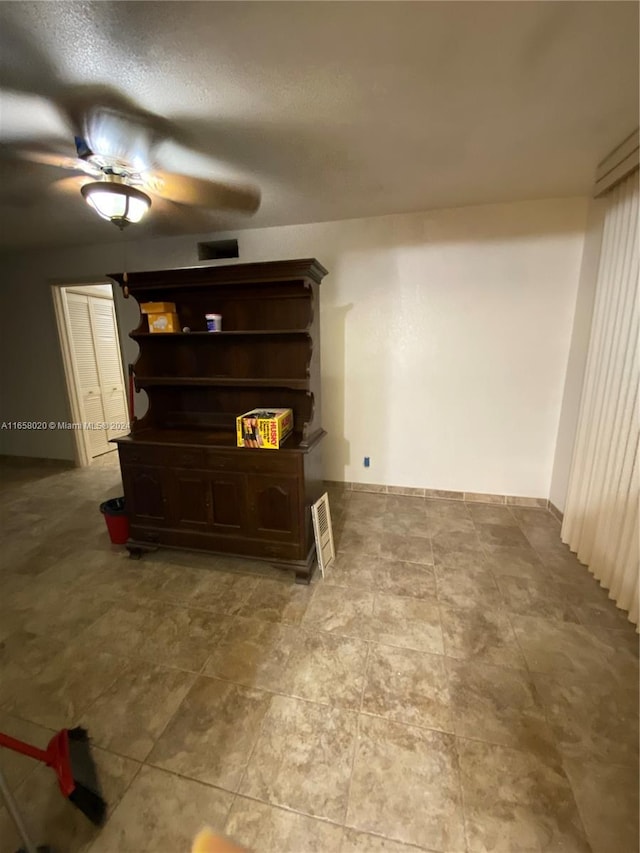 interior space with ceiling fan