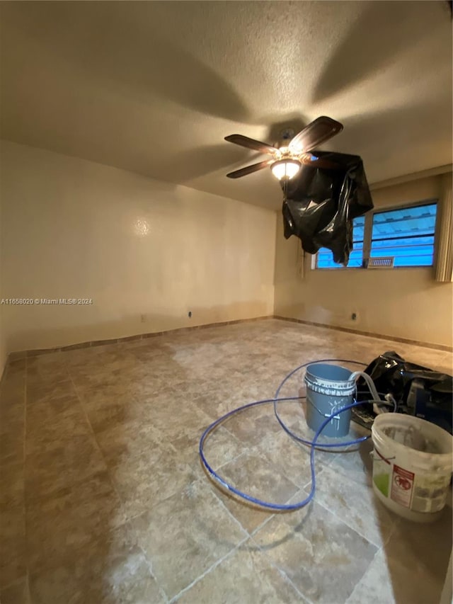 interior space with ceiling fan and a textured ceiling