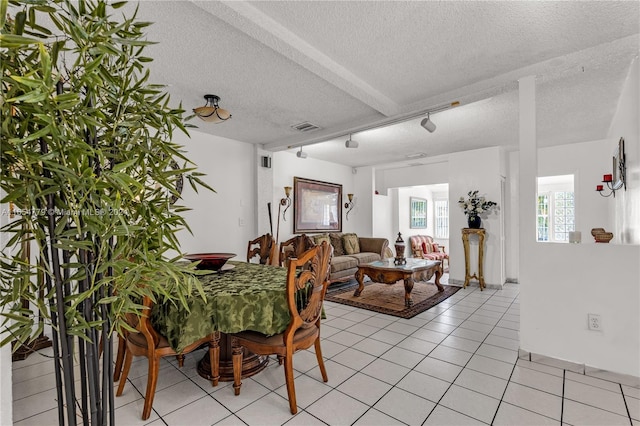 dining space featuring light tile patterned floors and a textured ceiling