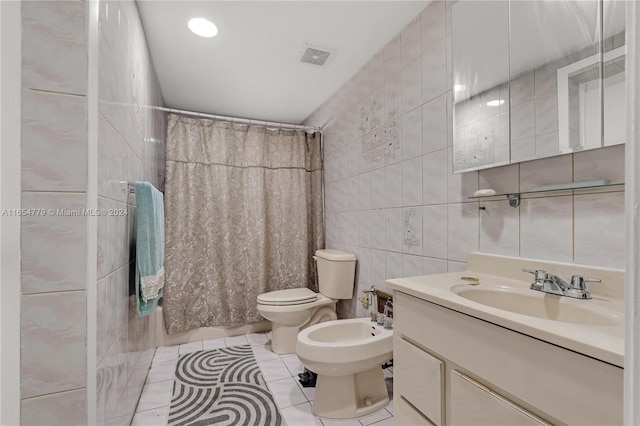 full bathroom with a bidet, vanity, tile patterned flooring, tile walls, and toilet