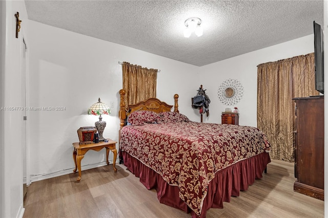 bedroom featuring a textured ceiling and light wood-type flooring