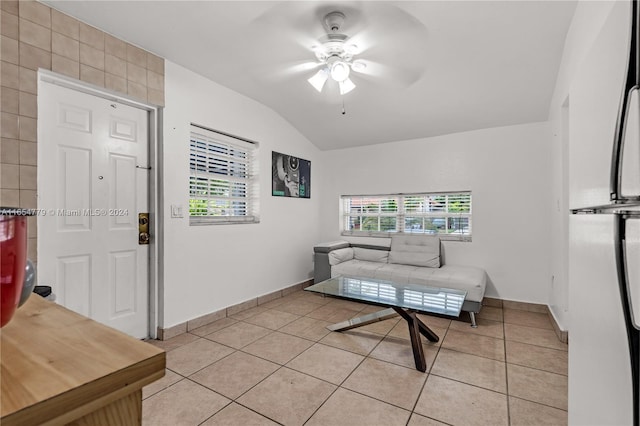 living room featuring vaulted ceiling, light tile patterned floors, and ceiling fan