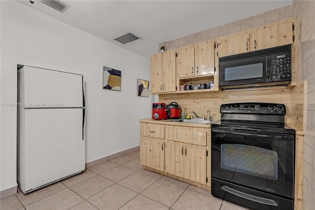 kitchen with light tile patterned floors, black appliances, sink, and light brown cabinets