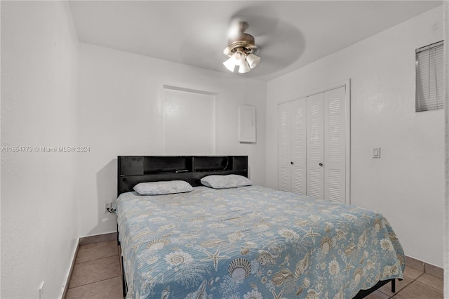 tiled bedroom with ceiling fan and a closet