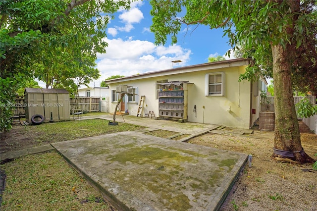 rear view of house with a shed and a patio area