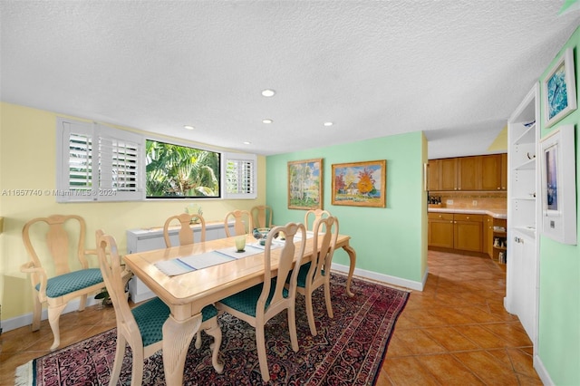 dining room featuring a textured ceiling and light tile patterned floors