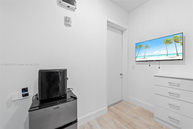 interior space featuring stainless steel refrigerator, white cabinets, and light hardwood / wood-style floors