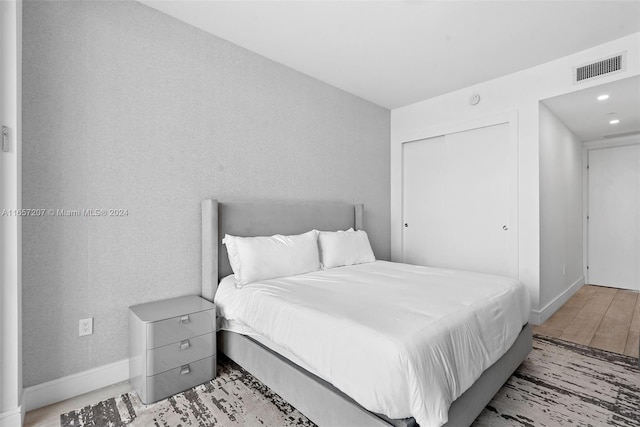 bedroom with a closet and light hardwood / wood-style flooring