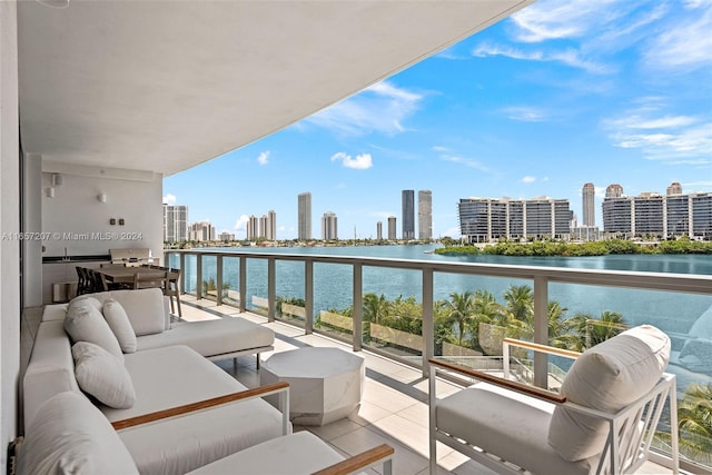 balcony featuring an outdoor living space, sink, and a water view