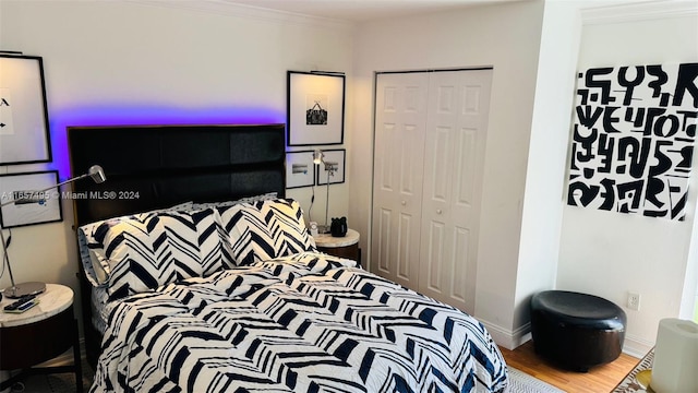 bedroom featuring crown molding, hardwood / wood-style flooring, and a closet