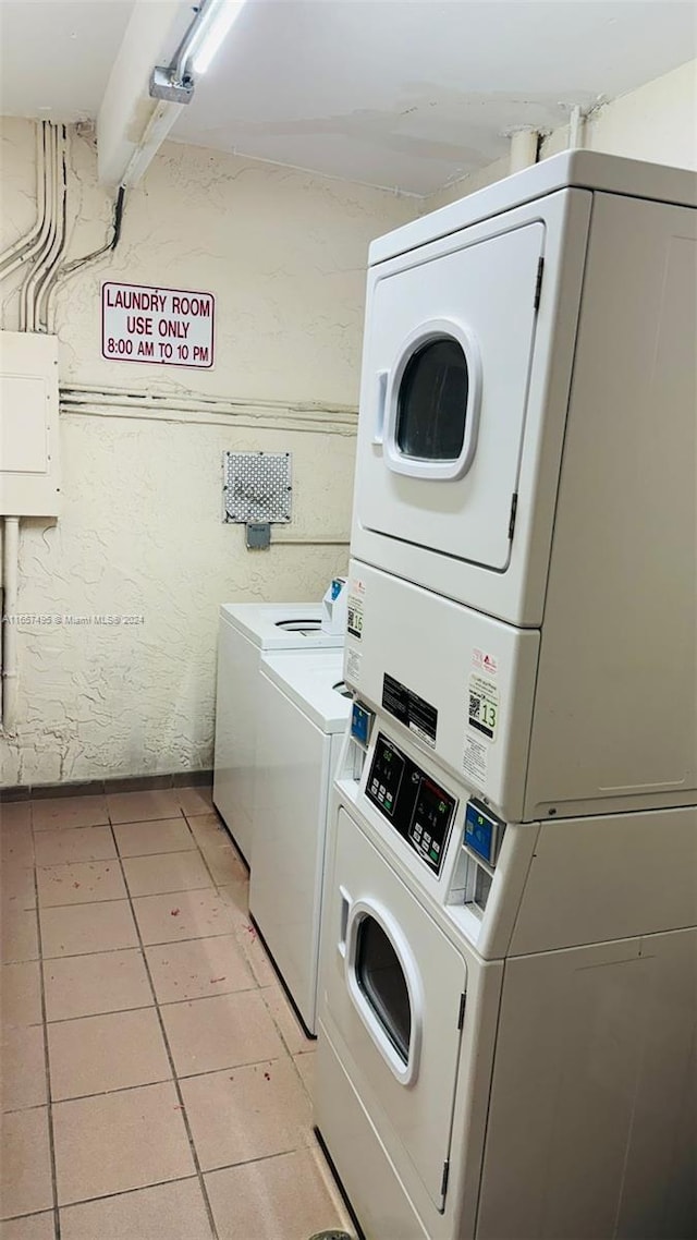 washroom featuring light tile patterned floors, electric panel, washer and dryer, and stacked washer / dryer