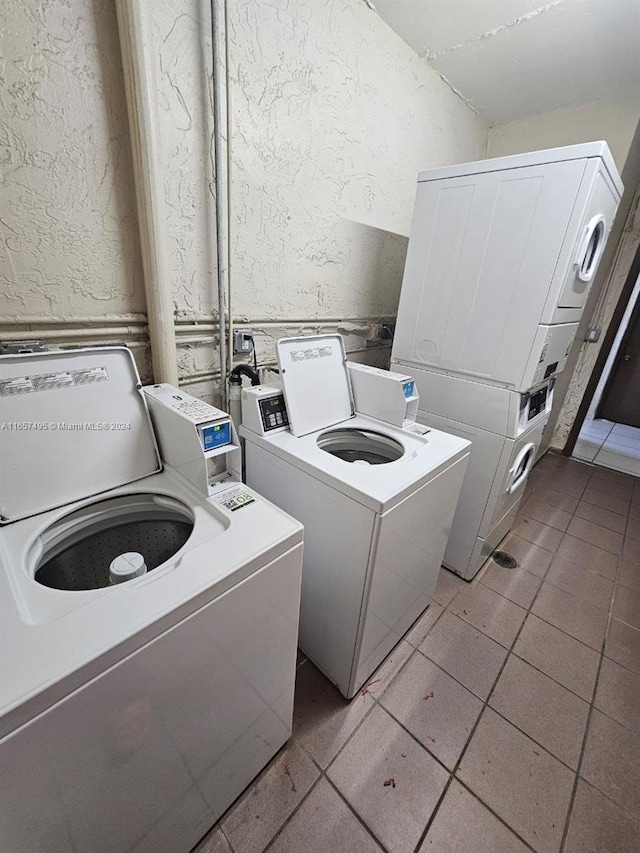 laundry area with washer and dryer, light tile patterned floors, and stacked washer / drying machine