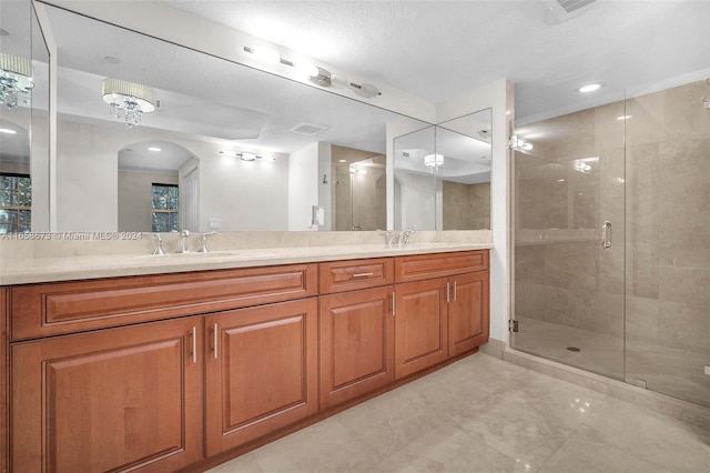 bathroom featuring an enclosed shower, a textured ceiling, and vanity