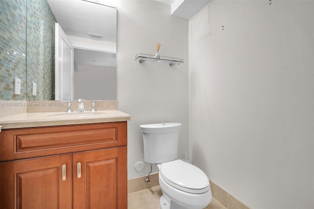 bathroom featuring tile patterned floors, toilet, a textured ceiling, and vanity