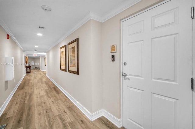 hallway with ornamental molding and light wood-type flooring