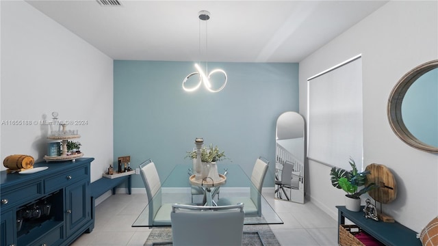 dining space with light tile patterned floors and a notable chandelier