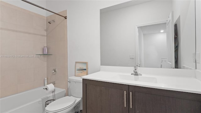 full bathroom featuring tiled shower / bath, vanity, and toilet