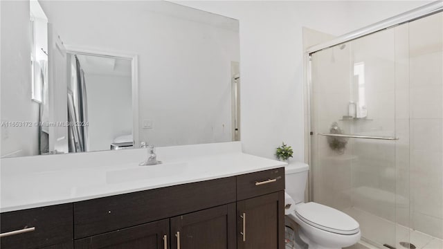 bathroom featuring an enclosed shower, vanity, and toilet