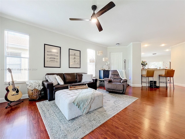 living room with crown molding, dark wood-type flooring, and ceiling fan