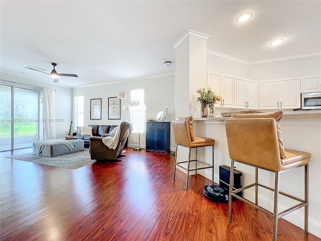 interior space with a breakfast bar, a healthy amount of sunlight, and white cabinets