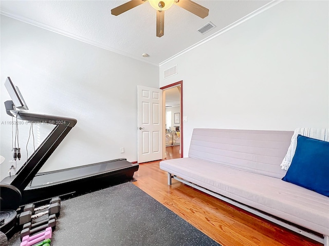 living area featuring ceiling fan, hardwood / wood-style flooring, a textured ceiling, and ornamental molding