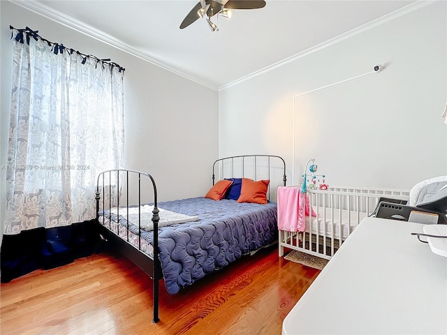 bedroom featuring ceiling fan, ornamental molding, and hardwood / wood-style floors