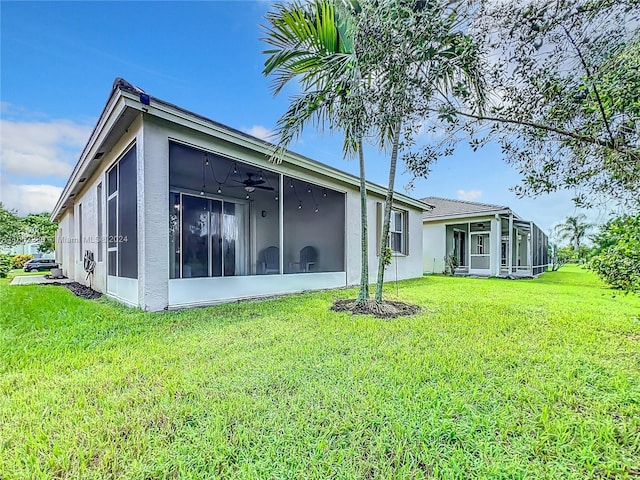 rear view of property featuring a lawn and a sunroom