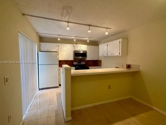 kitchen with kitchen peninsula, white cabinets, stainless steel appliances, and a textured ceiling