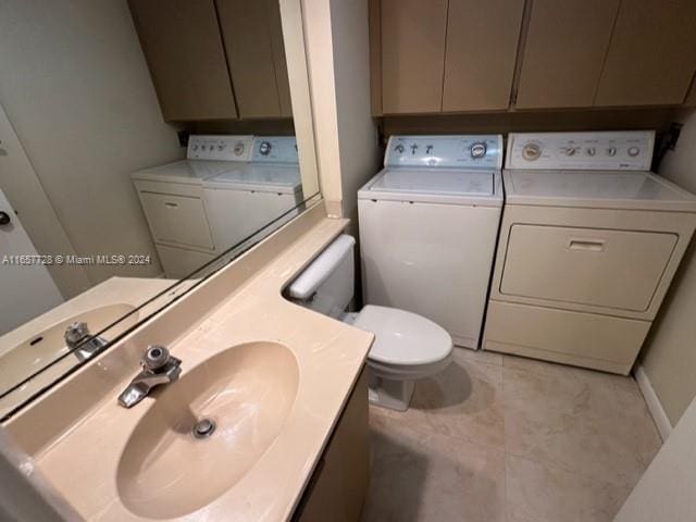 bathroom featuring tile patterned floors, toilet, separate washer and dryer, and sink