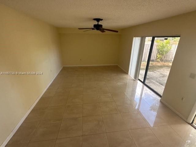 spare room featuring light tile patterned floors, a textured ceiling, ceiling fan, and lofted ceiling