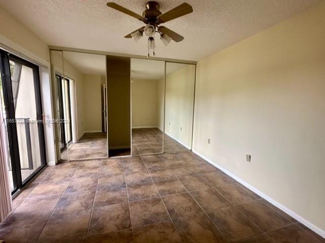 spare room with a textured ceiling and ceiling fan