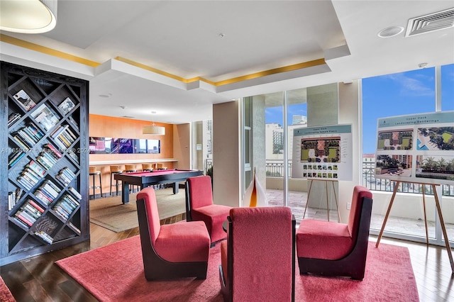 dining area featuring a tray ceiling, hardwood / wood-style floors, and a wall of windows