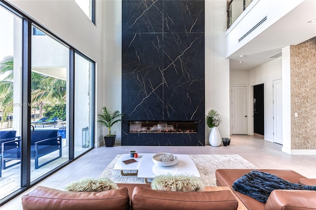 living room featuring a high end fireplace and a towering ceiling