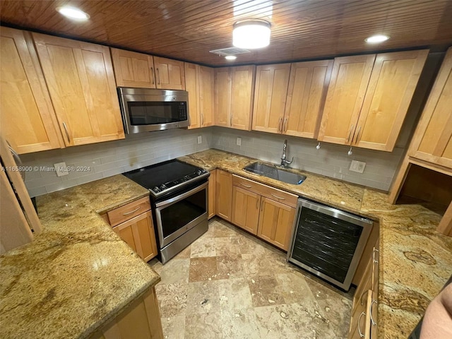 kitchen with appliances with stainless steel finishes, wine cooler, tasteful backsplash, and sink