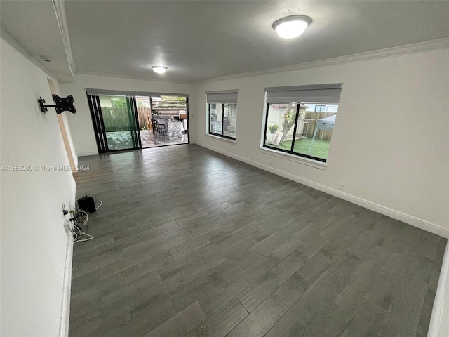 unfurnished living room with ornamental molding and dark wood-type flooring