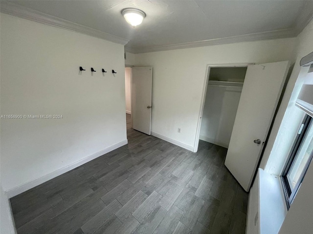 unfurnished bedroom with ornamental molding, dark wood-type flooring, and a closet