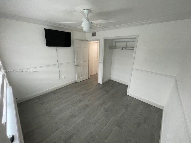 unfurnished bedroom featuring dark wood-type flooring, a closet, and ceiling fan