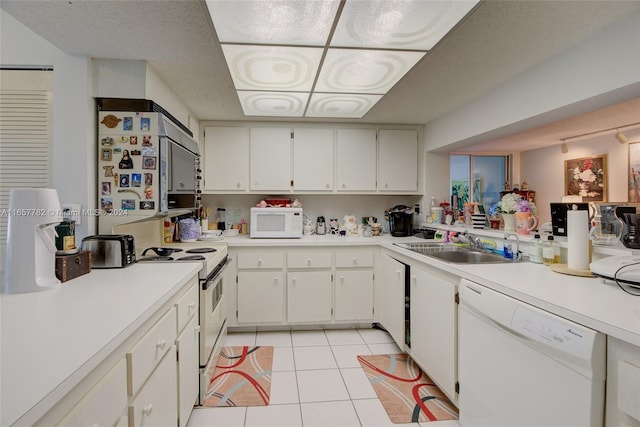 kitchen with a textured ceiling, sink, white cabinets, white appliances, and light tile patterned floors