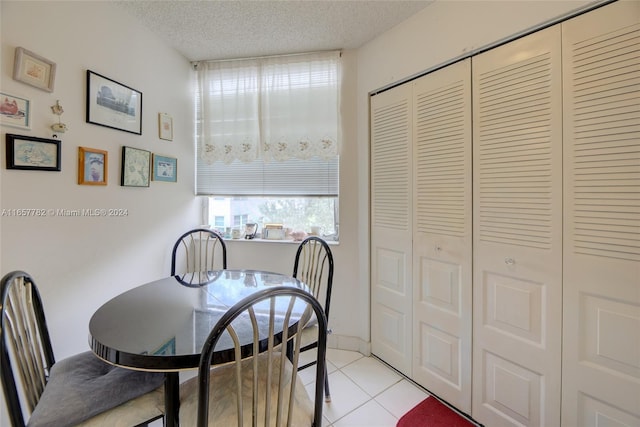 tiled dining area with a textured ceiling