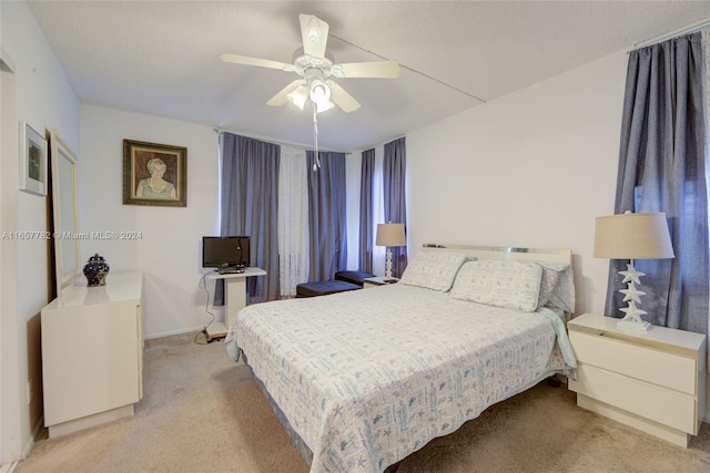 carpeted bedroom featuring a textured ceiling and ceiling fan