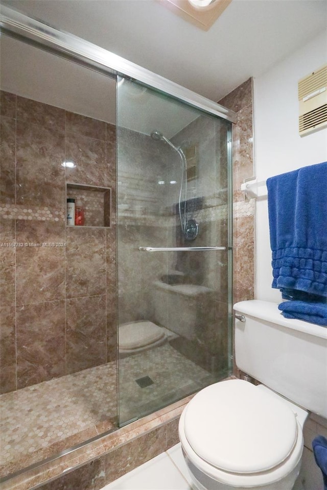 bathroom with walk in shower, tile patterned flooring, and toilet