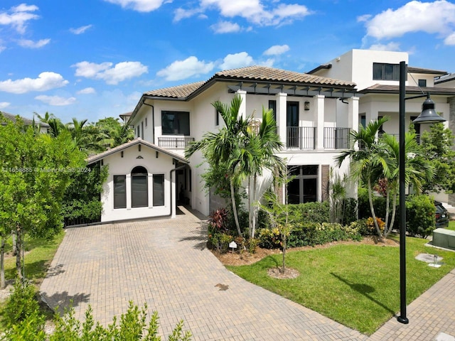 mediterranean / spanish home with a balcony and a front yard