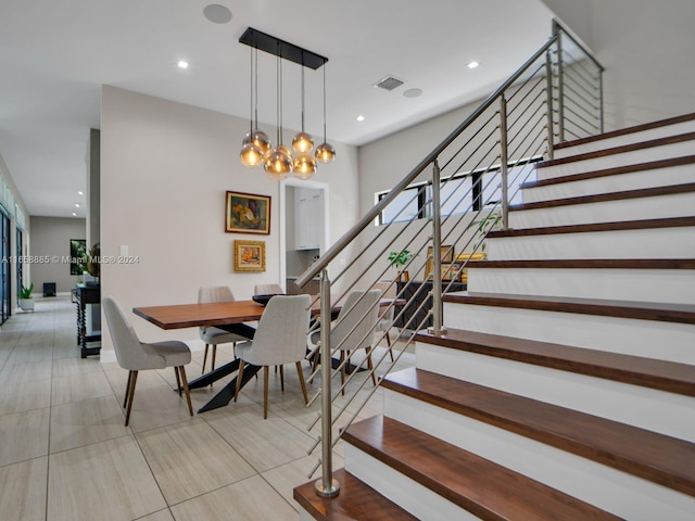 stairs featuring an inviting chandelier