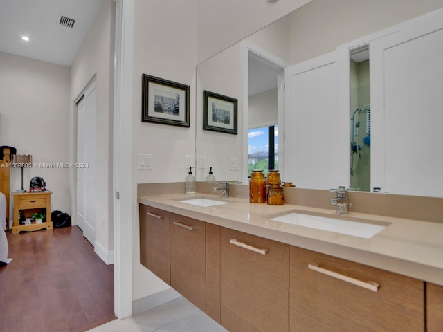 bathroom with walk in shower, vanity, and hardwood / wood-style flooring