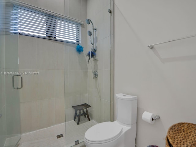 bathroom with toilet and an enclosed shower