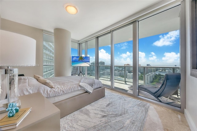 bedroom featuring access to exterior and a wall of windows