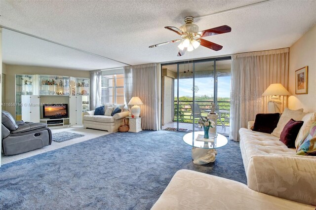 living room featuring ceiling fan, a wall of windows, carpet floors, and a textured ceiling