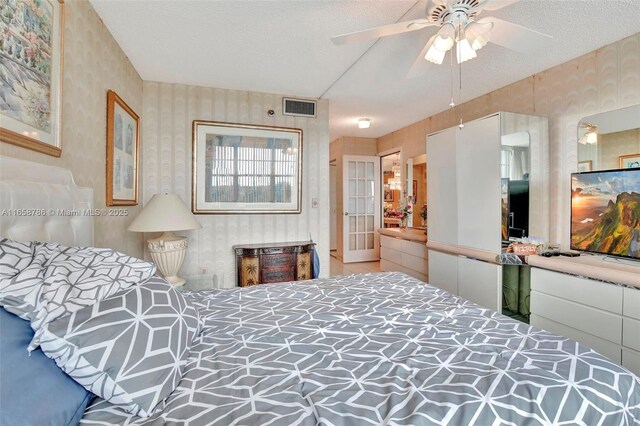 living room with carpet flooring, ceiling fan with notable chandelier, and a textured ceiling