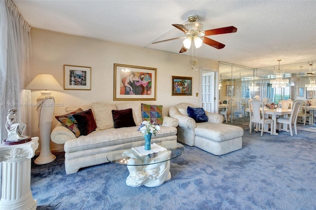 living room with carpet flooring, ceiling fan with notable chandelier, and a textured ceiling